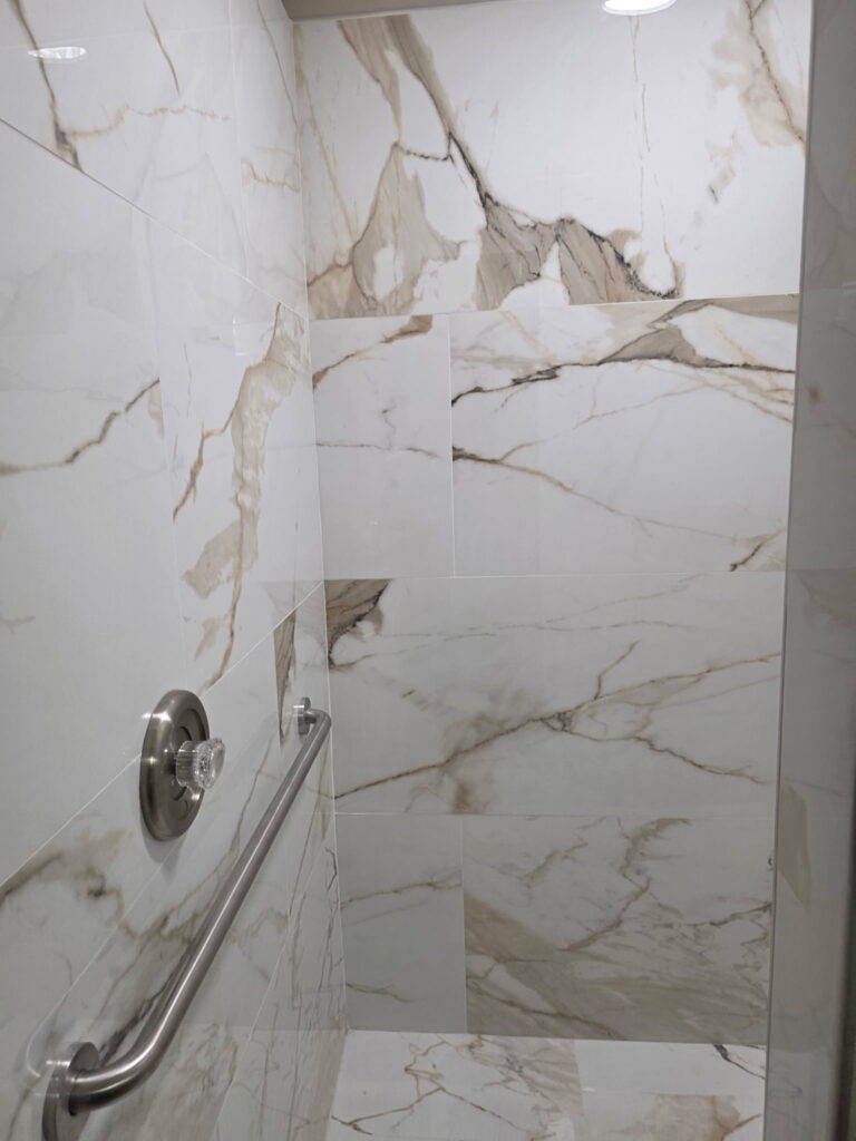 Marble-pattern shower tile and grab-bar detail